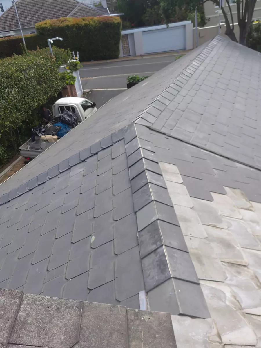 Slate roof under repair, high-angle diagonal view of a pitched roof