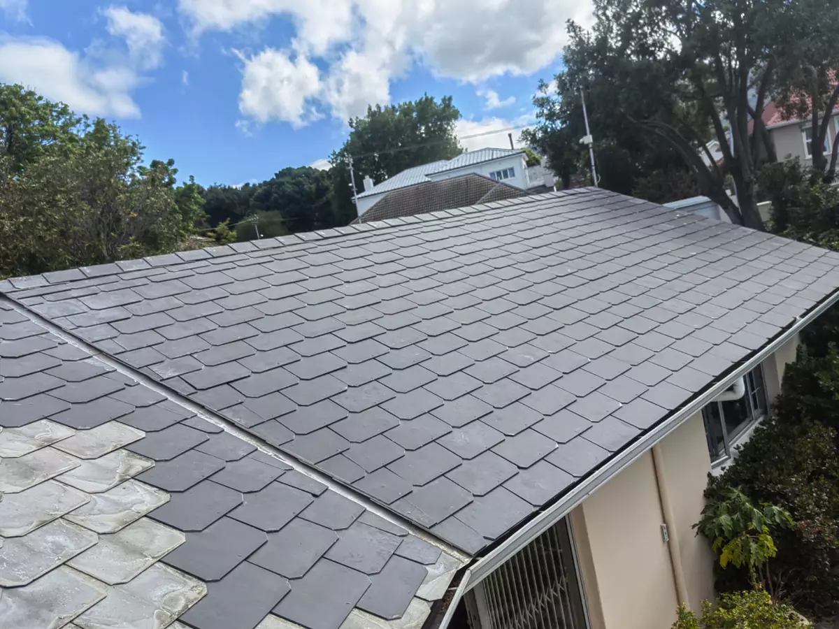 Newly shingled grey slate roof against a blue sky